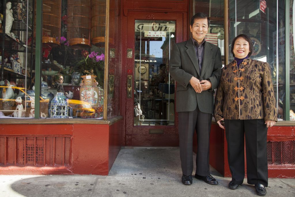 Asian couple in front of their store